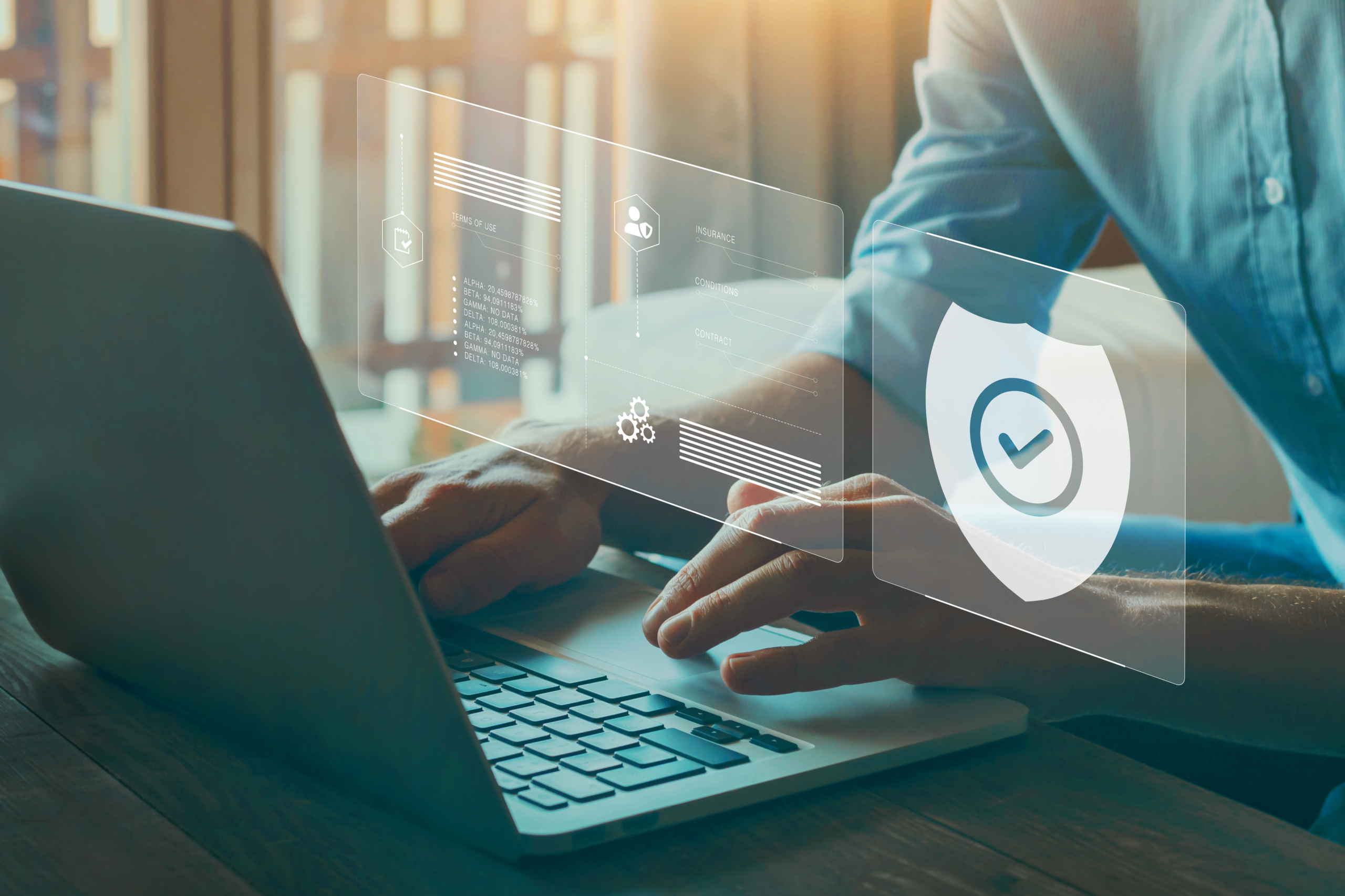 Professional using a laptop with digital security shield and verification interface representing technology risk management and compliance.